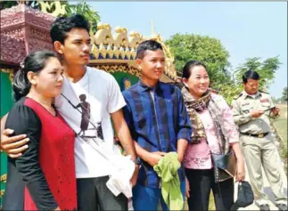  ?? SUPPLIED ?? Mother Nature activists Dem Kundy (second left) and Hun Vannak (third right) stand with their mothers outside Koh Kong Provincial Prison after their release yesterday.