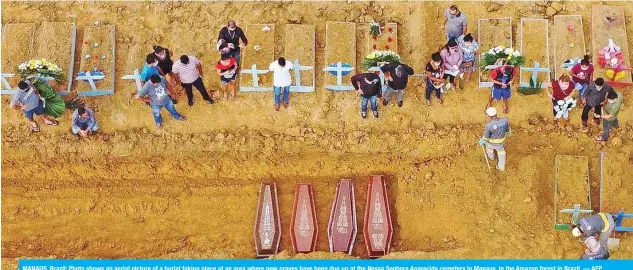  ?? — AFP ?? MANAUS, Brazil: Photo shows an aerial picture of a burial taking place at an area where new graves have been dug up at the Nossa Senhora Aparecida cemetery in Manaus, in the Amazon forest in Brazil.