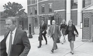  ?? JEFFREY COLLINS/AP ?? Former SCANA CEO Kevin Marsh, center, walks out of a courtroom Thursday with his lawyers after being sentenced to two years in prison for lying and deceiving the public about the progress of a pair of nuclear reactors in South Carolina that were never finished and wasted billions of dollars.
