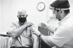  ?? THOM BRIDGE/INDEPENDEN­T RECORD ?? Montana Gov. Greg Gianforte receives a shot of the Pfizer COVID-19 vaccine in April from a pharmacist at a Walgreens in Helena, Montana.