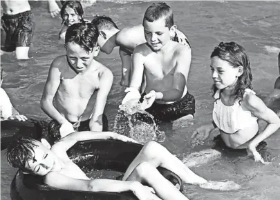  ?? THE COMMERCIAL APPEAL FILES ?? When the temperatur­e nears 100, what could be better than to lie in an inner tube and have your playmates splash cool water all over you? This scene at Guthrie Playground's wading pool in the first week of June 1953 was typical of many all over the...