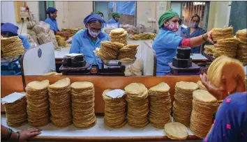  ??  ?? Photograph shows staff of Shri Mahila Griha Udyog weigh and pack rolled papadums at one of the organisati­on’s facilities in Mumbai.