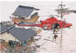  ?? FOTO: AP ?? Auch in der Präfektur Okayama gab es große Überschwem­mungen. Menschen retteten sich auf Dächer und warteten auf Hilfe.