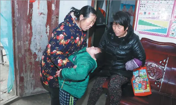  ?? ZHU LIXIN / CHINA DAILY ?? Song Jinlan (left) says she feels most desperate when her grandson (center) falls sick.