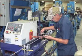  ?? File, Doug Walker / Rome News-Tribune ?? Russell Morrow works on a line in the Suhner Manufactur­ing plant in Rome.