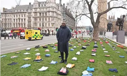  ?? ?? Idris Elba stands in Parliament Square in London with bundles of clothing representi­ng lives lost to knife crime in the UK. Photograph: Dave Benett/Alan Chapman/Getty Images