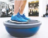  ??  ?? Exercises that focus on balance — like this one, using a Bosu ball — can prevent falls in those who are over age 65 or suffer from certain diseases.