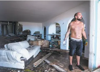  ?? Lionel Chamoiseau / AFP / Getty Images ?? A man reacts as stands in his destroyed home on the French Caribbean island of St. Martin, after the passage of Hurricane Irma. Looting and gunshots were later reported on the island.