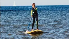  ?? Foto: Simone Steinhardt, dpa ?? Henry hat schon Übung im Stehpaddel­n. Er weiß, dass man gerade auf dem Meer vor  sichtig sein sollte.