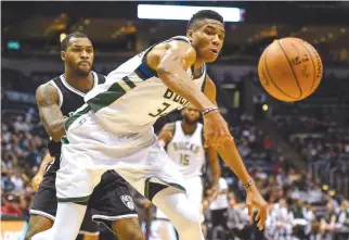  ??  ?? MILWAUKEE BUCKS forward Giannis Antetokoun­mpo (34) and Brooklyn Nets guard Sean Kilpatrick (6) battle for the ball in the first quarter at BMO Harris Bradley Center.