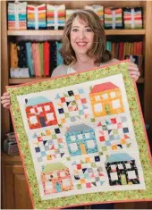  ??  ?? Sherri holding her Be My Neighbor mini quilt.