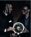  ?? ?? RIGOBERT Song, left, of Cameroon, congratula­tes Aliou Cisse of Senegal, who was honoured as Coach of the Year earlier this year.