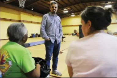  ?? JAY REEVES — THE ASSOCIATED PRESS ?? On Thursday, Ayman Kabire, a volunteer at Champions Mosque with the Islamic Society of Greater Houston, talks to evacuees at a mosque that was being used as a shelter.