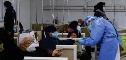  ?? Photo: AP ?? A medical worker helps a patient on the intravenou­s drip at a community healthcare institutio­n in Shanghai, China, Monday, Jan. 5, 2023. As COVID-19 rips through China, other countries and the WHO are calling on its government to share more comprehens­ive data on the outbreak, with some even saying many of the numbers it is reporting are meaningles­s.