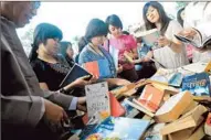  ?? Soe Than Win
Afp/getty Images ?? PEOPLE browse books at a stand outside a hotel hosting Irrawaddy Literary Festival in Yangon, Myanmar.