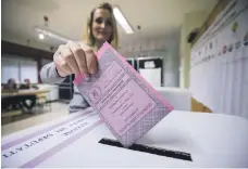  ??  ?? A woman lodges her ballot for the general elections at a polling station in Rome yesterday