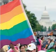  ?? JOSE LUIS MAGANA/AP ?? A person waves a rainbow flag as they participan­t in a rally in support of the LGBTQIA+ community at Freedom Plaza in Washington on June 12.