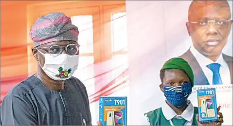  ??  ?? Lagos State Governor, Babajide Sanwo- Olu ( left) and beneficiar­y, Miss Sherifat Umar of Elegbata Senior High School, Lagos Island during First Bank of Nigeria’s presentati­on of 20,000 E- Learning devices to schools in Lagos … yesterday.