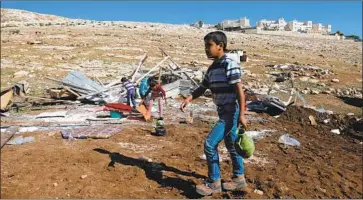  ?? Abbas Momani AFP/Getty Images ?? YOUNG Palestinia­n Bedouins at homes demolished by Israel near the Maale Adumim settlement in 2016.