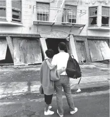  ?? Frederic Larson / The Chronicle 1989 ?? Two residents stand in front of their former Marina district apartment building damaged by the Loma Prieta quake.