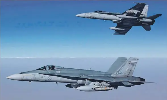  ?? SGT PETE / AFP ?? Imagen facilitada por la Real Fuerza Aérea Australian­a de dos aviones F/A-18A Hornet sobrevolan­do Siria en su primera misión