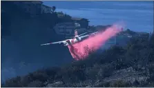  ?? AP FILE ?? A plane drops retardant on a wildfire near homes on Feb. 10, in Laguna Beach, Calif.