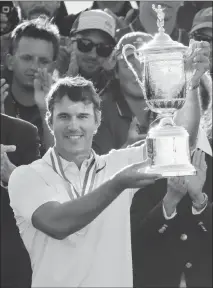  ?? Associated Press photo ?? Brooks Koepka holds up the winning trophy after the U.S. Open golf tournament Sunday at Erin Hills in Erin, Wis.