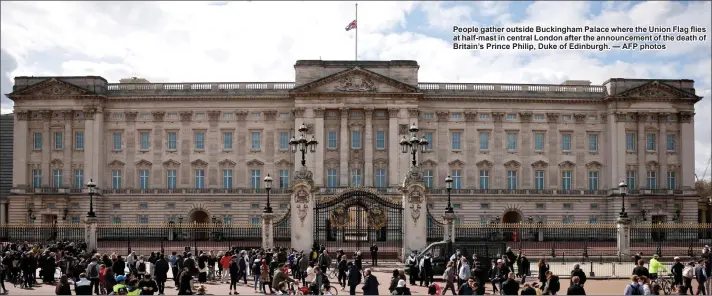  ?? — AFP photos ?? People gather outside Buckingham Palace where the Union Flag flies at half-mast in central London after the announceme­nt of the death of Britain’s Prince Philip, Duke of Edinburgh.