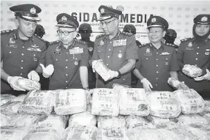  ?? — Gambar Bernama ?? TERBESAR: Subromania­m (tengah) diberi penerangan mengenai dadah yang dirampas oleh Pengarah Kastam Kedah Datuk Johari Alifiah (dua kiri) ketika mengadakan sidang media di Pejabat Kastam Bukit Kayu Hitam dekat Bukit Kayu Hitam, semalam.