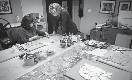  ?? Photos by Timothy Hurst, Daily Camera ?? Rita Vali, left, and Robyn Rathweg work to create panels of mosaic tiles that will be installed in the McCaslin Boulevard pedestrian underpass this year.