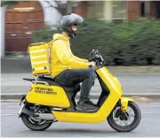  ?? REUTERS ?? A Yango Deli staff member drives an electric moped in London.