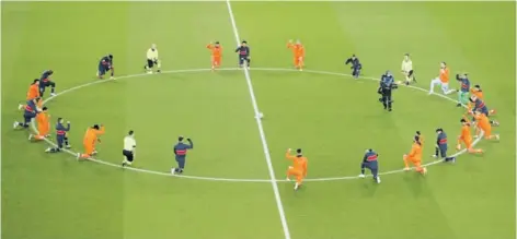  ??  ?? Los jugadores del PSG y del Istanbul Basaksehir, además de los arbitros, de rodillas como señal contra el racismo.