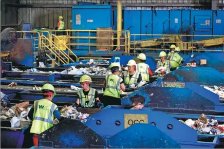  ?? SAUL LOEB / FOR CHINA DAILY ?? Workers sort material for recycling at the Waste Management Material Recovery Facility in Elkridge, Maryland, United States, in June. For months, this major recycling facility for the Greater Baltimore-Washington Area has been paying to get rid of huge amounts of paper and plastic it would normally have sold to China.