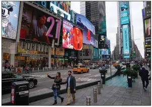  ?? People walk through Times Square while taking pictures Monday in New York City. (AP/Seth Wenig) ??
