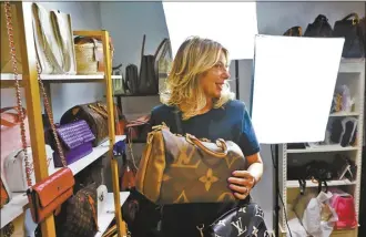  ?? AP photo ?? Deborah Mayer holds one of the luxury handbags she sells on TikTok on March 21, in Freehold, N.J. Mayer has sold new and pre-owned handbags and other designer goods out of her New Jersey home for 16 years. Early last year, TikTok recruited her business for the live component of TikTok Shop.