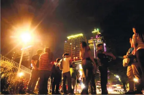  ?? (SUN.STAR FOTO/ALEX BADAYOS) ?? REFUGE. Last Friday night’s earthquake drove many people outside, like these call center workers who sought refuge inside the Fuente Osmeña Circle.