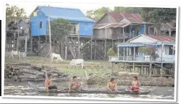  ??  ?? Men fishing along the river with stilt houses along the bank