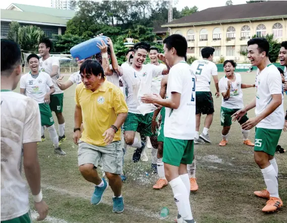  ?? SUNSTAR FOTO / ARNI ACLAO ?? NOT ME. Coach Allan Medalla runs away before his players could pour water on him during USC’s celebratio­n of its fourth straight Cesafi football title.