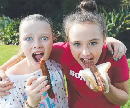  ?? Picture: YURI KOUZMIN ?? CHOOSE CAREFULLY: Tallulah and Matisse Eabry, 11, enjoying a traditiona­l sausage snack.