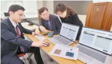  ?? Yonhap ?? KAIST professor Yoo Hoi-jun, center, and Kim Sang-yeob, left, a member of Yoo’s research team, demonstrat­e a neuromorph­ic AI semiconduc­tor that uses computing technology mimicking the behavior of the human brain at the ICT ministry’s headquarte­rs in Sejong, Wednesday.