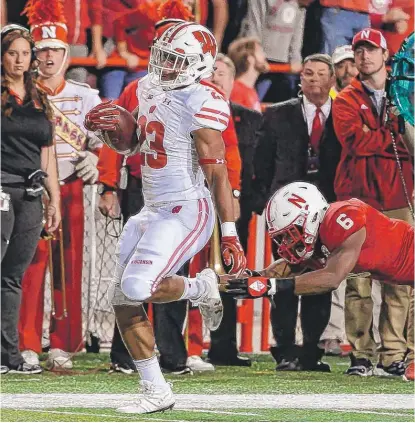  ?? | GETTY IMAGES ?? Wisconsin running back Jonathan Taylor outruns Nebraska’s Eric Lee Jr. to score one of his two touchdowns Saturday.