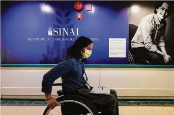  ?? Photos by Charles Rex Arbogast/Associated Press ?? Jonathan Annicks wheels past a photo of himself at Schwab Rehabilita­tion Hospital in Chicago, where he recovered from the gunshot wounds that paralyzed him in 2016, when he was 18.
