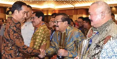  ?? PEMPROV JATIM FOR JAWA POS ?? CAPAIAN POSITIF: Presiden Joko Widodo menyerahka­n langsung piala Penghargaa­n Pembanguna­n Daerah (PPD) 2018 kepada Gubernur Jawa Timur Soekarwo di Jakarta pada 30 April lalu.