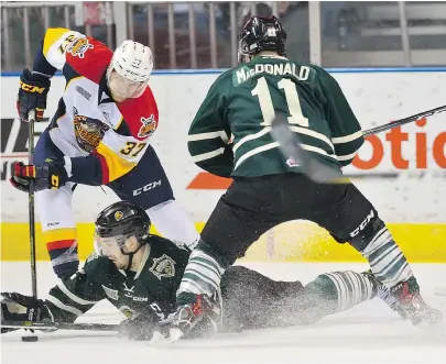  ?? MORRIS LAMONT/POSTMEDIA NEWS FILES ?? London Knights defenceman Evan Bouchard is careful not to put his hand on the puck with Erie forward Warren Foegele and Knights forward Owen MacDonald in the first period of game three of their playoff series at Budweiser Gardens in London, Ont., in 2017.
