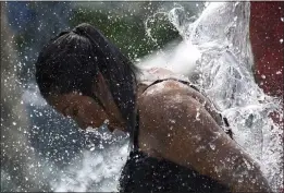  ?? NAM Y. HUH — THE ASSOCIATED PRESS ?? A woman cools off at a fountain in Mount Prospect, Ill., during Thursday's heat. High temps across a vast area of the U.S. are expected to last into the weekend.