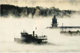  ?? ROBERT F. BUKATY/AP ?? Sea smoke rises Saturday from the Atlantic Ocean as a ferry passes Spring Point Ledge Light near South Portland, Maine. The temperatur­e was about minus 10.