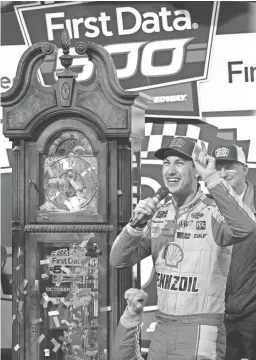 ?? STEVE HELBER/AP ?? Joey Logano celebrates with the trophy grandfathe­r clock after winning the Monster Energy NASCAR Cup Series auto race in Martinsvil­le, Va.