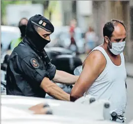  ?? TONI ALBIR / EFE ?? Un mosso custodia a uno de los presuntos yihadistas detenidos ayer