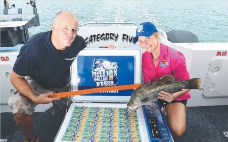  ??  ?? CrownBet’s Brad Fanning and Outback Float Planes operator Bonnie Keogh with a freshly tagged Million Dollar Fish competitio­n barra