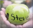  ?? PICTURE: REUTERS ?? RIP: A woman holds an apple with the name of Steve Jobs written on it.